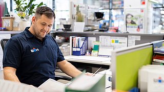 Verkäufer der Baustoffe am Schreibtisch