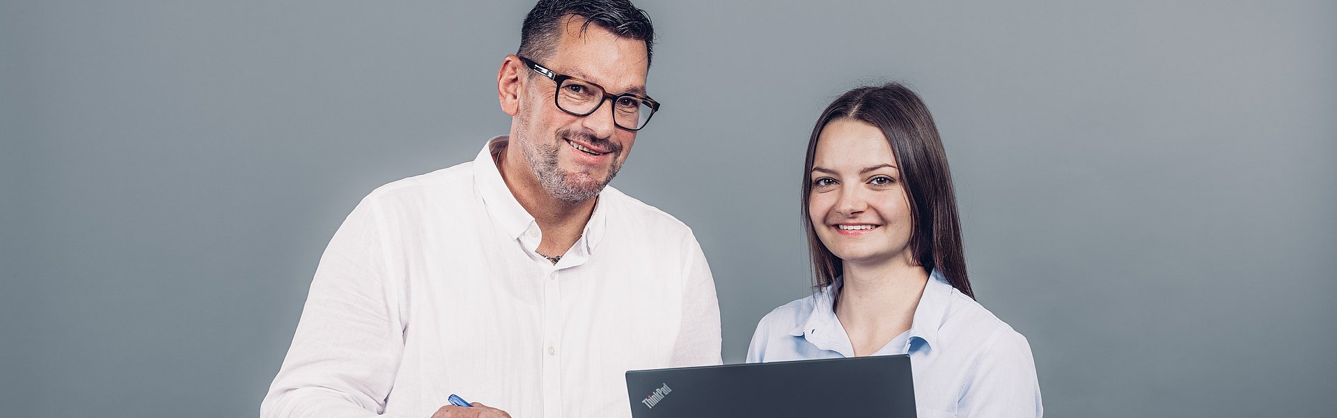 Zwei WH Mitarbeiter beim Planen am Laptop und Notizblock