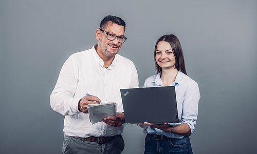 Zwei WH Mitarbeiter beim Planen am Laptop und Notizblock